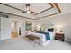 Main bedroom showing the tray ceiling, a stylish upholstered headboard, and a glass doored beverage refrigerator at 10114 Meade Ct, Westminster, CO 80031