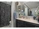 Classic bathroom featuring black and white tile, a shower with a floral curtain, and an updated vanity at 15393 E Louisiana Ave, Aurora, CO 80017