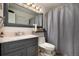 Neat bathroom featuring updated vanity, toilet and tub/shower combo with grey shower curtain at 15393 E Louisiana Ave, Aurora, CO 80017