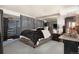 Spacious bedroom featuring gray walls and flooring, mirrored wall, and a comfortable king-sized bed at 15393 E Louisiana Ave, Aurora, CO 80017