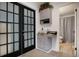 Hallway space featuring a full view door with blinds, a printer station, and a toilet room at 15393 E Louisiana Ave, Aurora, CO 80017