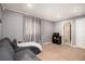 Cozy living room with plush carpeting, modern gray walls, and a view of the adjacent bathroom at 15393 E Louisiana Ave, Aurora, CO 80017