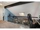 Cozy loft area with skylight and railing overlooking living space with fireplace, and black beam accent at 15393 E Louisiana Ave, Aurora, CO 80017