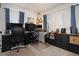 Bright home office featuring a large desk, multiple monitors, and soft natural light from the sheer curtains at 15393 E Louisiana Ave, Aurora, CO 80017