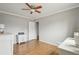 Bright bedroom featuring hardwood floors, white trim, and a ceiling fan for added comfort at 9271 Gaylord St, Thornton, CO 80229