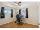 Comfortable bedroom features wood floors, a ceiling fan, and two windows for natural light at 9271 Gaylord St, Thornton, CO 80229