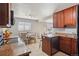 Well-lit eat-in kitchen features wooden cabinets, granite countertops, and stainless steel dishwasher at 9271 Gaylord St, Thornton, CO 80229