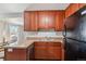 Kitchen features wood cabinets, granite countertops, and stainless steel double sink at 9271 Gaylord St, Thornton, CO 80229