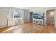 Bright living room with hardwood floors, large window and a TV above a sideboard cabinet at 9271 Gaylord St, Thornton, CO 80229