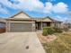 Charming single-Gathering home with a two-car garage and landscaped front yard with stone details at 381 Freestone St, Brighton, CO 80603