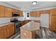 Well-lit kitchen with stainless steel appliances, wood cabinets, and an island counter at 381 Freestone St, Brighton, CO 80603