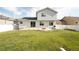 Spacious backyard with a fire pit, grassy lawn, and a white fence for privacy at 1507 Alpine Ave, Berthoud, CO 80513