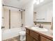 Bathroom featuring tiled shower and floors, a modern sink and vanity, and updated fixtures at 1507 Alpine Ave, Berthoud, CO 80513