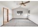 Bedroom featuring vaulted ceiling, ceiling fan, gray carpet, and two windows at 1507 Alpine Ave, Berthoud, CO 80513