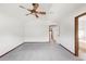Bedroom featuring vaulted ceiling, fan, gray carpet, and a window with door to bathroom at 1507 Alpine Ave, Berthoud, CO 80513