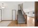 Hallway view of carpeted stairs, wood railings, white trim, and hardwood floors at 1507 Alpine Ave, Berthoud, CO 80513