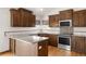 Bright kitchen with granite counters, stainless appliances, mosaic backsplash, wood cabinets, and hardwood floors at 1507 Alpine Ave, Berthoud, CO 80513