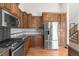 Bright kitchen with stainless steel appliances, granite countertops, wood cabinets, and hardwood floors at 1507 Alpine Ave, Berthoud, CO 80513