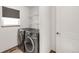 Clean laundry room with side-by-side washer and dryer, storage shelves, and window with blinds at 1507 Alpine Ave, Berthoud, CO 80513