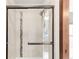 Shower with decorative tile detail and glass door at 1507 Alpine Ave, Berthoud, CO 80513