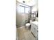 Well-lit bathroom with a white vanity, a black-framed mirror, and neutral tile flooring at 8209 Balsam Way, Arvada, CO 80005