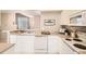 Modern kitchen with white cabinets, dishwasher, and electric range at 6448 Silver Mesa Dr # B, Highlands Ranch, CO 80130