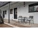 Outdoor porch seating area features a table, two chairs and a door to enter the unit at 4820 W 13 Ave, Denver, CO 80204