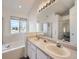 Main bathroom with double vanity, soaking tub, and separate shower at 10048 Deer Creek St, Highlands Ranch, CO 80129