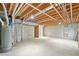 Unfinished basement space with concrete floor, exposed pipes, and open ceiling at 6973 W Louisiana Ave # E, Denver, CO 80232