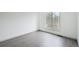 A bright bedroom features wood-look flooring and a large window at 6973 W Louisiana Ave # E, Denver, CO 80232
