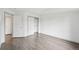 Bright bedroom features gray wood-look floors, closet and ensuite door, plus neutral walls at 6973 W Louisiana Ave # E, Denver, CO 80232