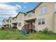 Multi-story tan townhome featuring a private deck and outdoor green space at 6973 W Louisiana Ave # E, Denver, CO 80232