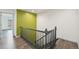 Hallway featuring wood-look floors, staircase and bright accent wall at 6973 W Louisiana Ave # E, Denver, CO 80232