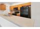 Well-lit kitchen features stainless steel appliances, wood cabinetry, and neutral countertops at 6973 W Louisiana Ave # E, Denver, CO 80232