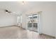 Bright living room with wood-look floors, airy curtains, and sliding glass doors that let in natural light at 6973 W Louisiana Ave # E, Denver, CO 80232