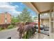 A quaint patio view with iron railing, landscaping and a wooden support beam that offers a relaxing outdoor living space at 6973 W Louisiana Ave # E, Denver, CO 80232