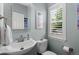 Powder room with a decorative mirror, vanity, and natural light that enhances a clean and inviting space at 8318 Devinney Ct, Arvada, CO 80005