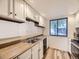 Well-lit kitchen featuring white cabinets, stainless steel appliances, and a breakfast bar at 2949 Shady Holw, Boulder, CO 80304