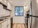 Efficient kitchen with white cabinets, stainless steel appliances, and a sunlit window at 2949 Shady Holw, Boulder, CO 80304