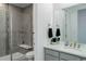 Modern bathroom featuring a tiled glass shower, gray vanity, and sleek fixtures with bright natural lighting at 22593 E Piccolo Way, Aurora, CO 80016