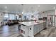 Open-concept kitchen featuring a large island with bar seating and seamless connection to the living area at 22593 E Piccolo Way, Aurora, CO 80016