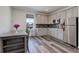 Well-lit kitchen showcasing gray cabinets, stainless steel appliances, stylish backsplash, and wood-look flooring at 22593 E Piccolo Way, Aurora, CO 80016