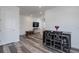 Open-concept living area with modern wood-look floors, neutral walls, television, and bright natural lighting at 22593 E Piccolo Way, Aurora, CO 80016