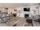 Open-concept living area connecting kitchen with a fireplace, a large TV, and a leather sofa at 22593 E Piccolo Way, Aurora, CO 80016