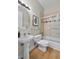 Bathroom with pedestal sink, decorative mirror, and shower-tub combo with glass doors at 45 N Ogden St # 201, Denver, CO 80218