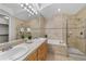 Bathroom featuring double sinks, tiled surround bathtub, and glass-enclosed shower at 45 N Ogden St # 201, Denver, CO 80218