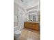 Bright bathroom featuring a double sink vanity, large mirror, and a white toilet at 45 N Ogden St # 201, Denver, CO 80218