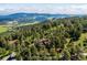Gorgeous aerial shot of a home surrounded by lush green trees with a view of distant mountains at 24999 Grandview Ave, Golden, CO 80401