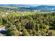 Beautiful aerial shot of a home surrounded by lush greenery with distant mountains in the background at 24999 Grandview Ave, Golden, CO 80401