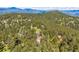 Panoramic aerial view showcasing a home surrounded by dense forest and mountain vistas at 24999 Grandview Ave, Golden, CO 80401